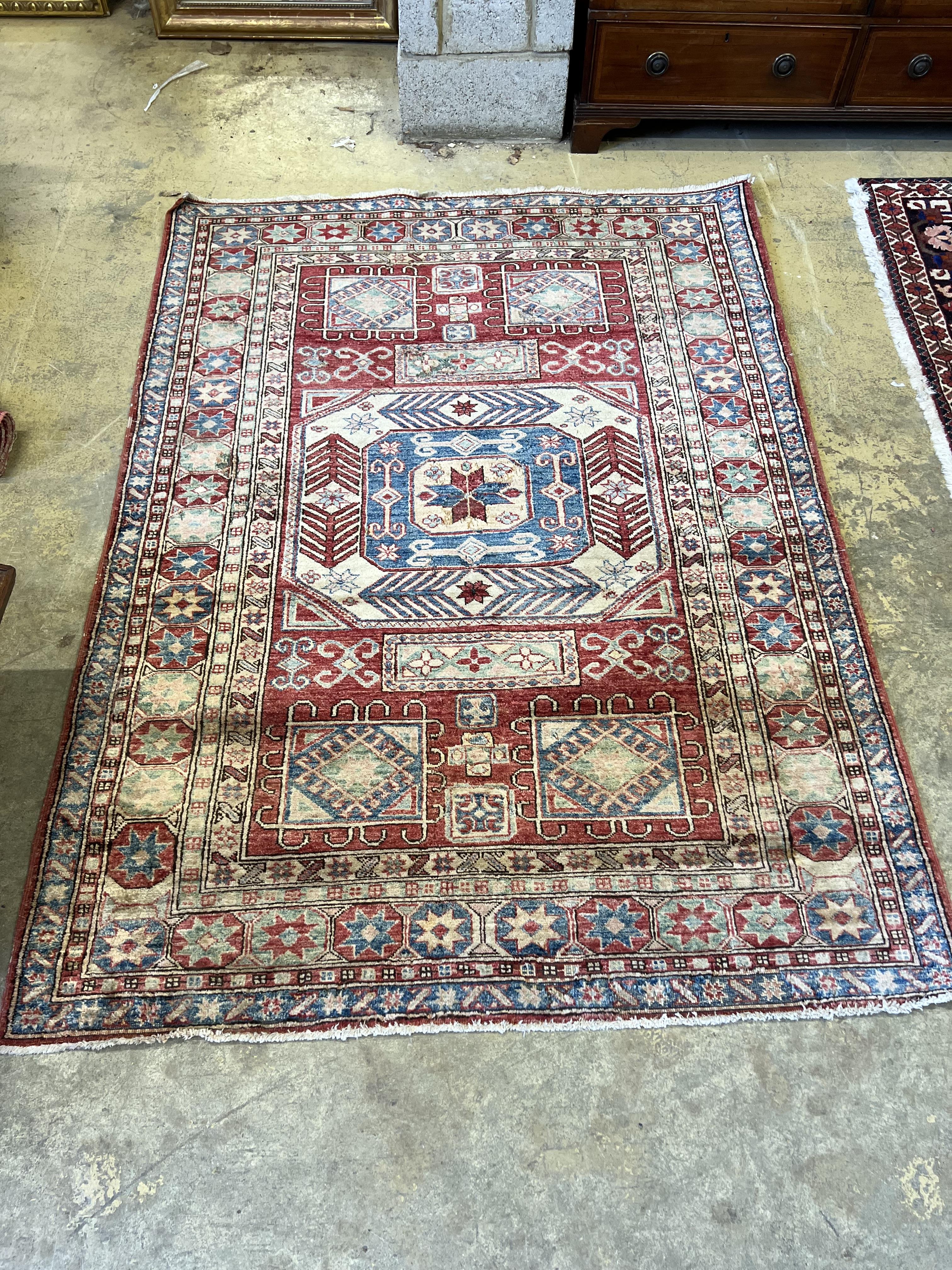 A Caucasian style red ground rug, 207 x 150cm